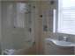 Crisp clean Bathroom with bath and shower .