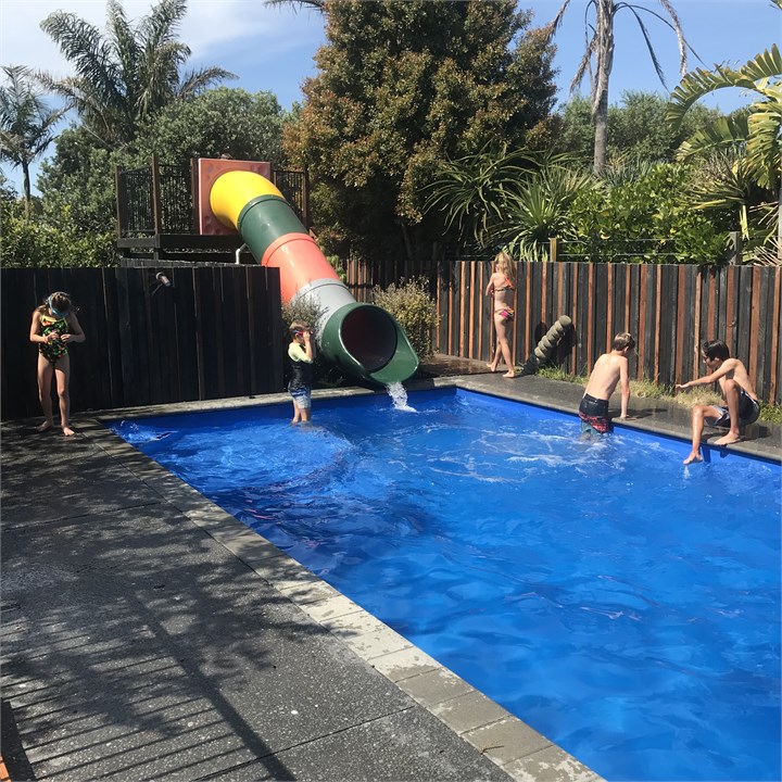 Pool with hydroslide and spa next to pool.