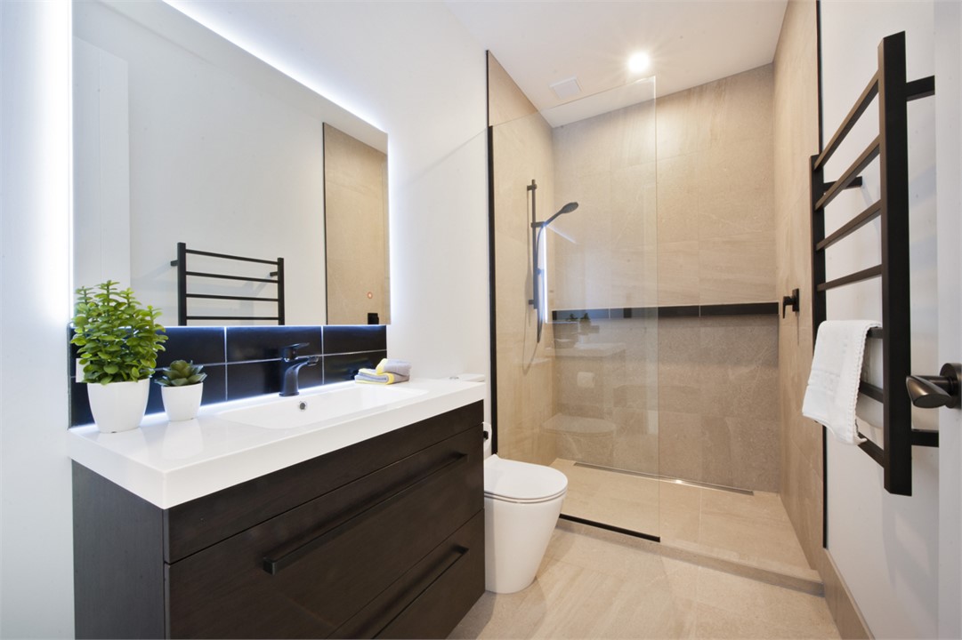 Main bathroom with walk in tile shower, toilet & v