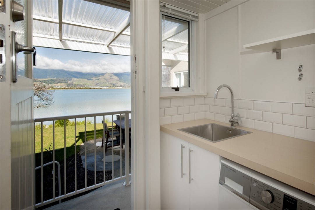 Laundry area with washer & tub. Dryer in garage