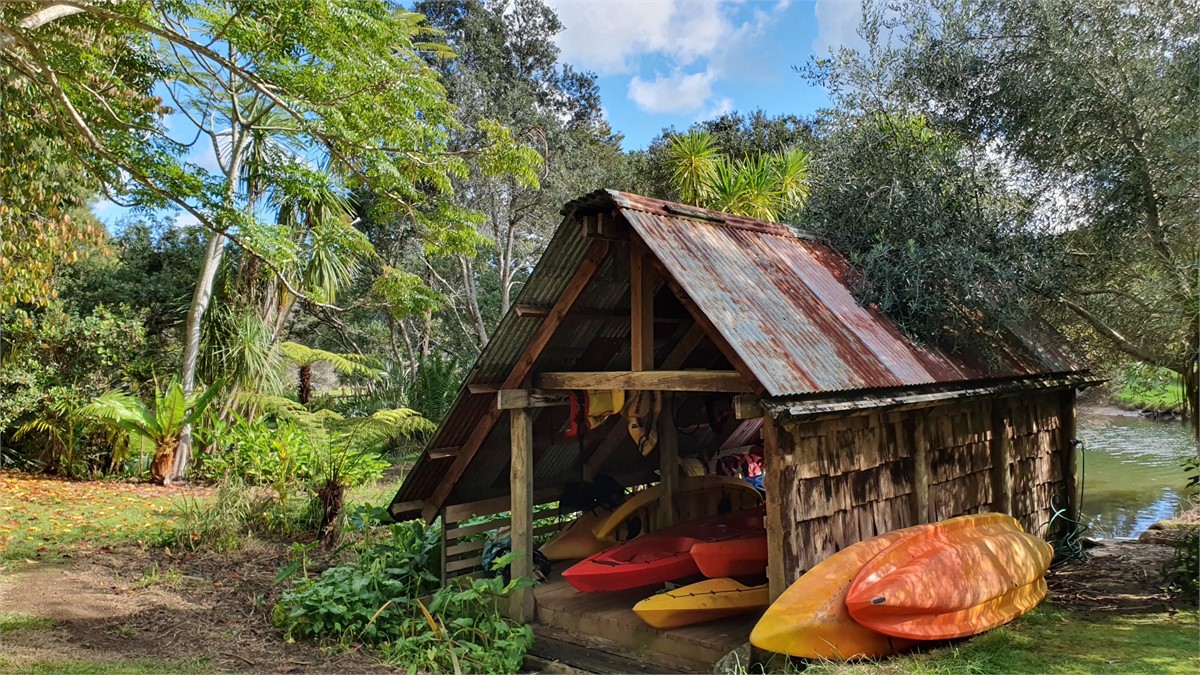 Boathouse with kayaks, canoes and fishing rods to