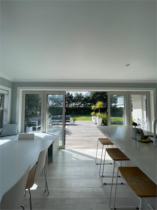 Glass doors open fully onto deck