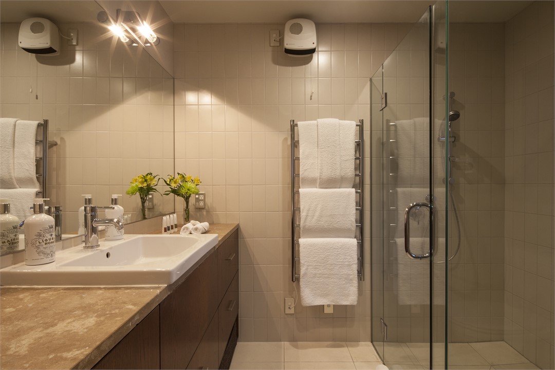 Large marble topped en-suite bathroom with glass s