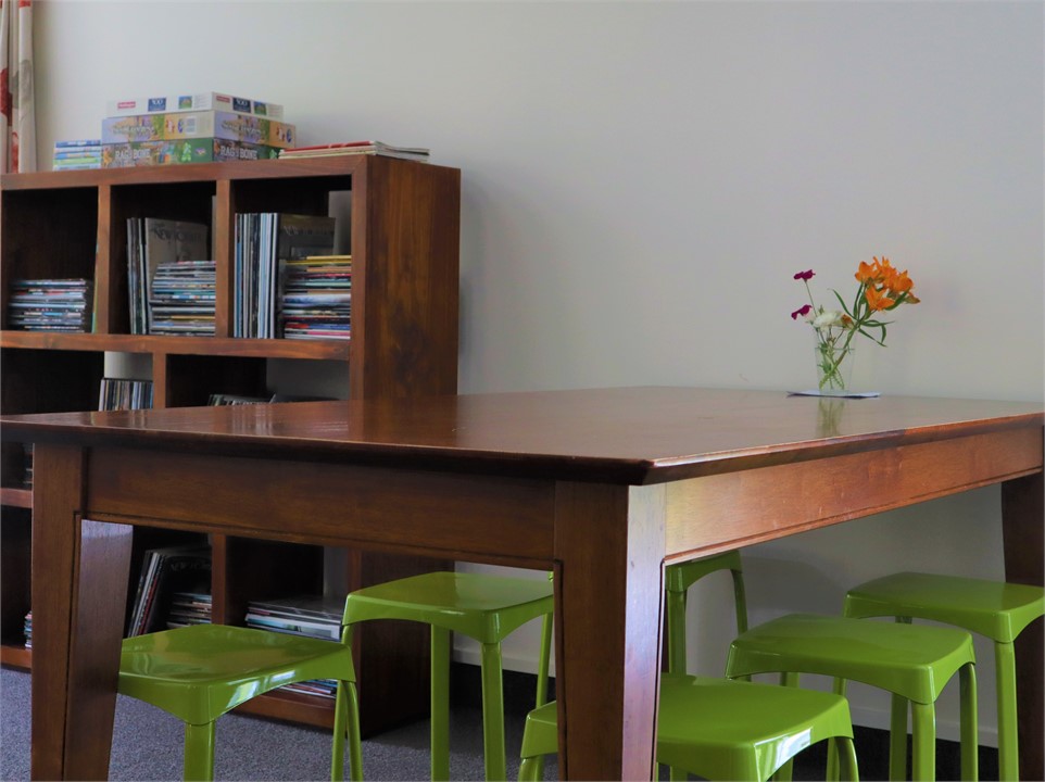 Dining table and bookshelf full of New Yorker maga