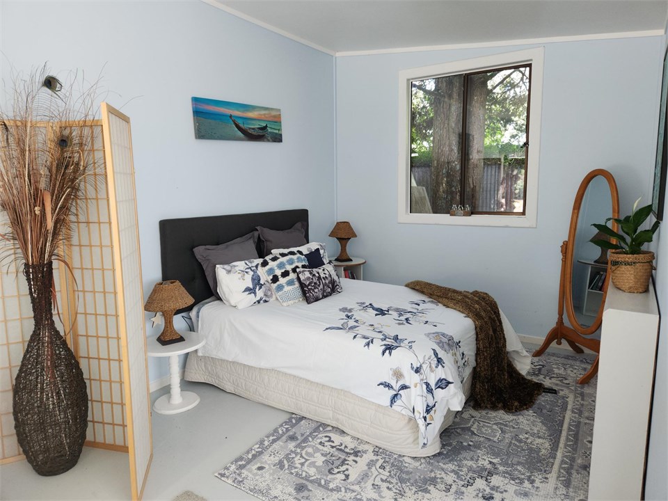 Bedroom with queen bed. Bed has an electric blanke