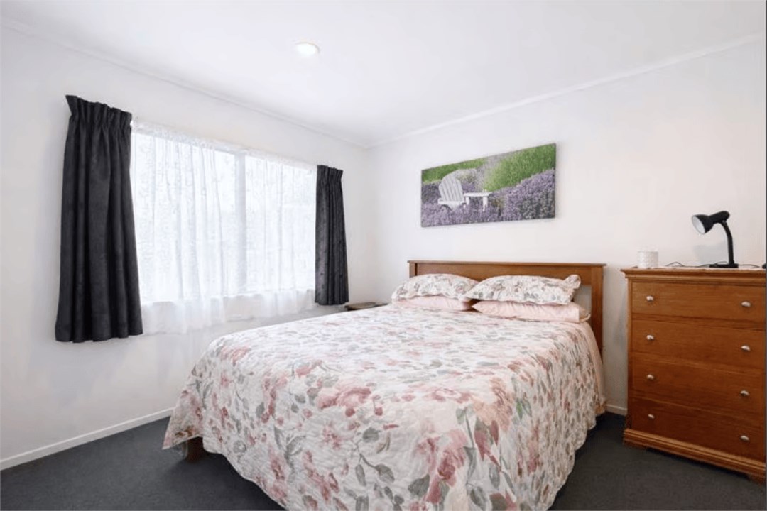 Sunny queen bedroom with soft natural light