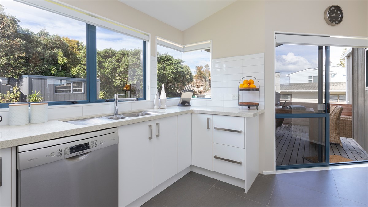 Kitchen opening onto back deck with open fireplace