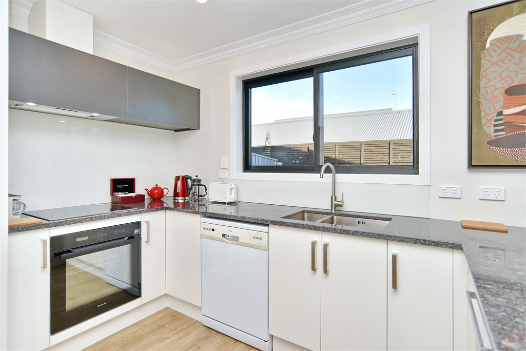 Full kitchen with a sitting area at the bench