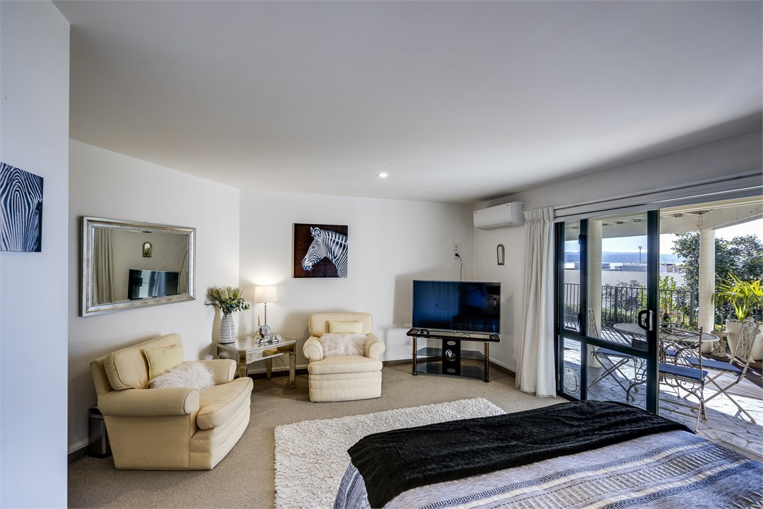 Spacious bedroom with Smart TV and easy chairs