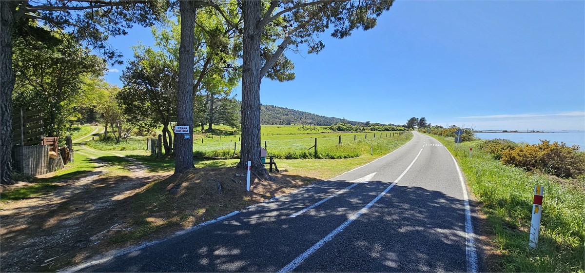 Entrance drive off main road with beach just acros