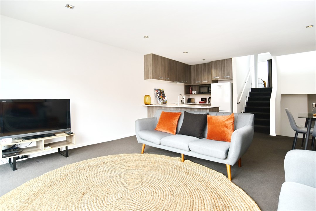 Living area with TV and Kitchen in the background