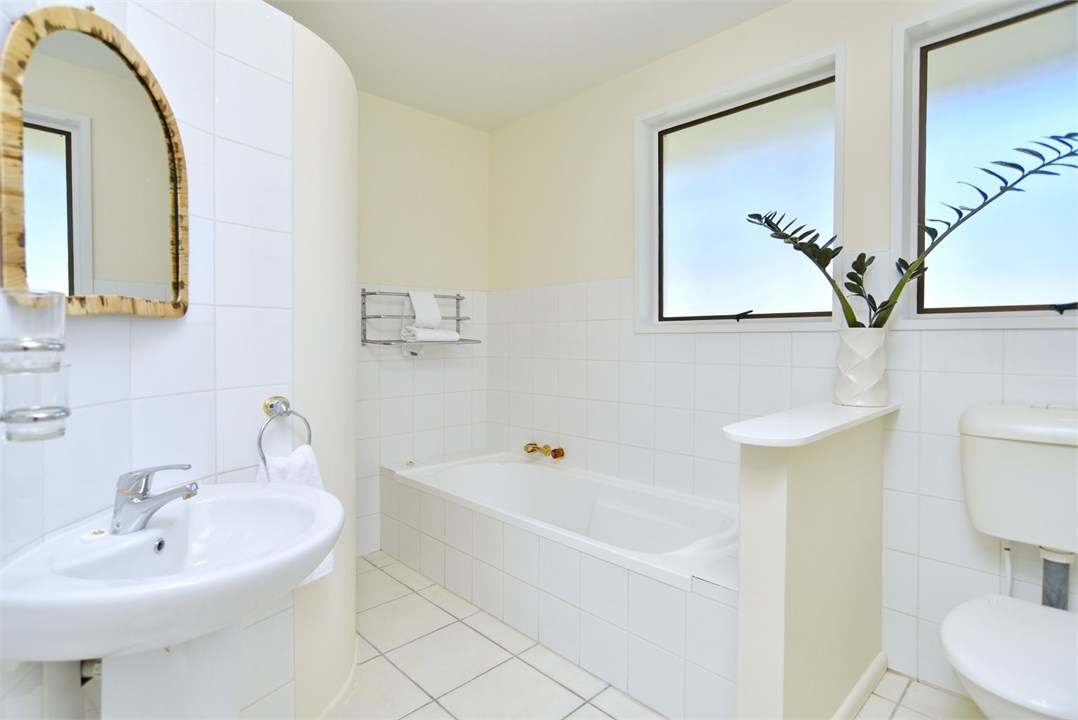 Bathroom 1 has a shower, bathtub and a toilet