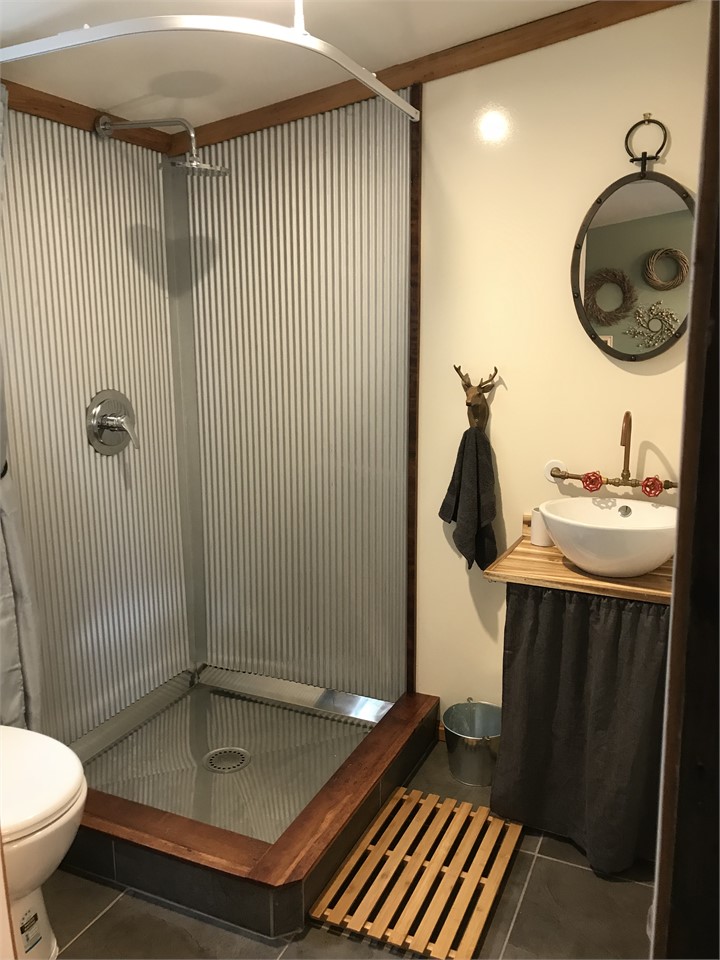 Bathroom is small and quaint and has artists raku