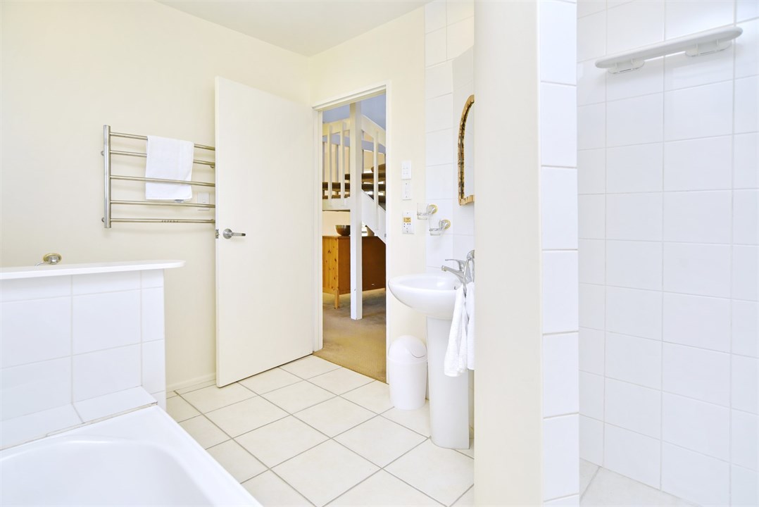 Bathroom 1 has a shower, bathtub and a toilet