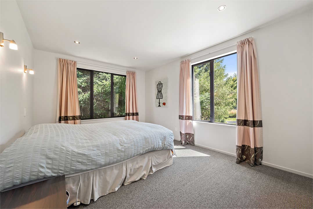 Bedroom 1 is a queen bed with views to the trees