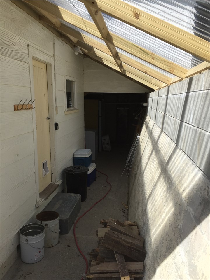 covered dry area behind the house