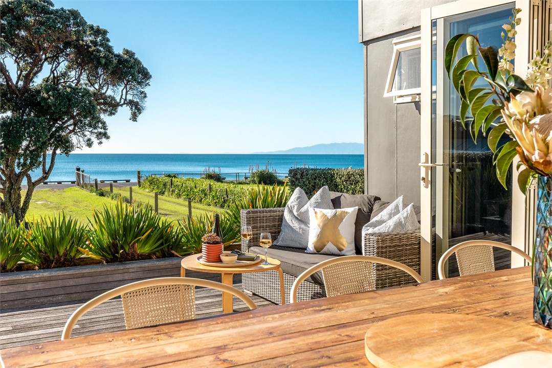 Dining area opening onto large deck with sea view