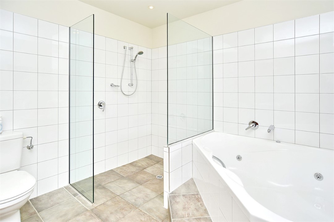 En suite to Bedroom 1 with a spa bath, shower and 