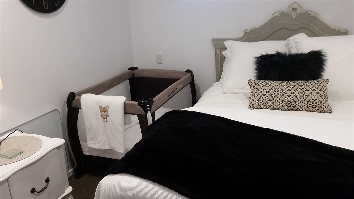 Queen bedroom showing porta cot setup