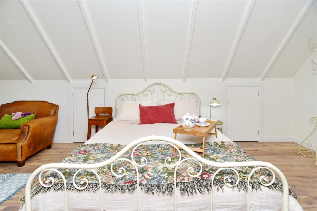 Bedroom has a Queen sized bed and a sitting area