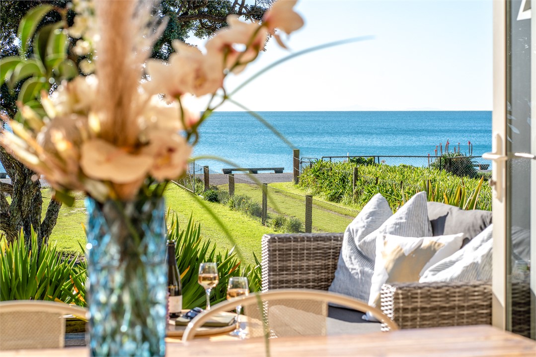 Dining area opening onto large deck with sea view