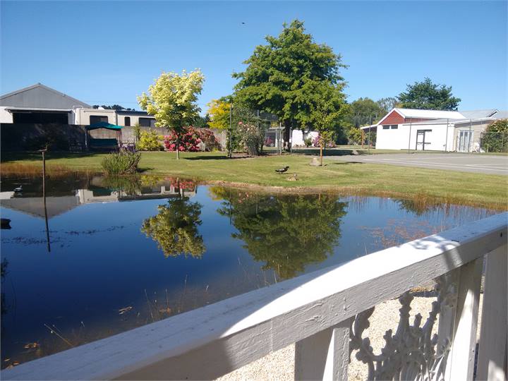 Looking across water t Tennis court Barns & cottag