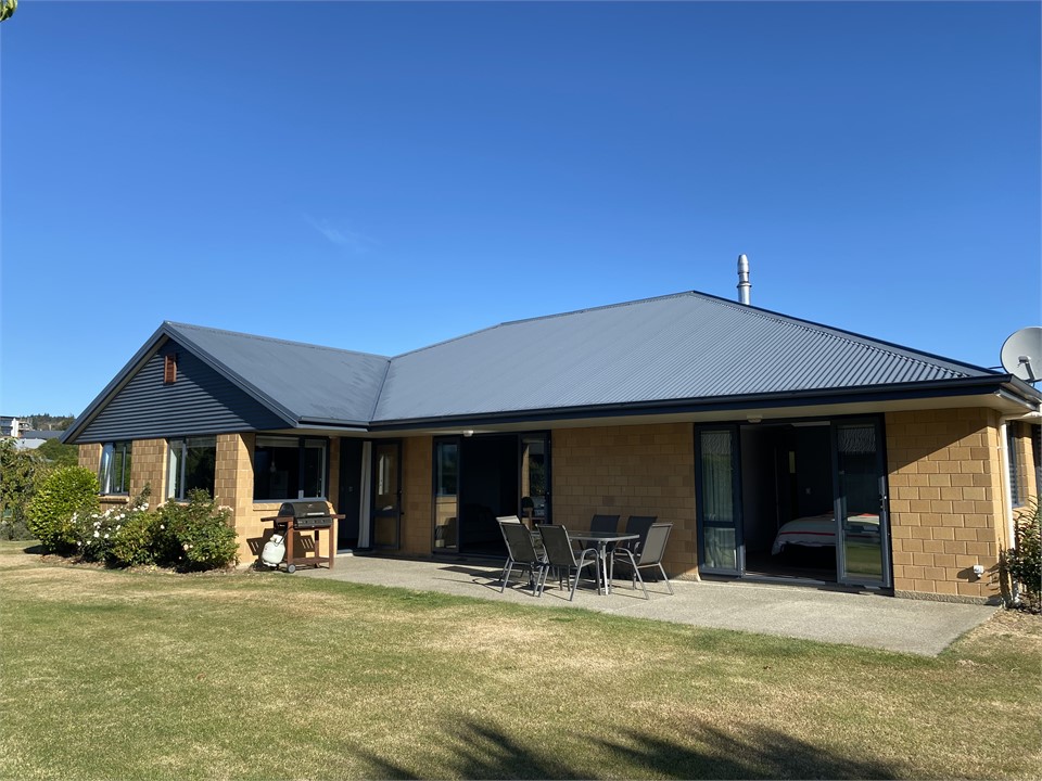 Large covered patio with outdoor furniture and BBQ