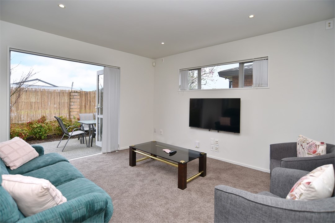 Living room with seating areas and a TV
