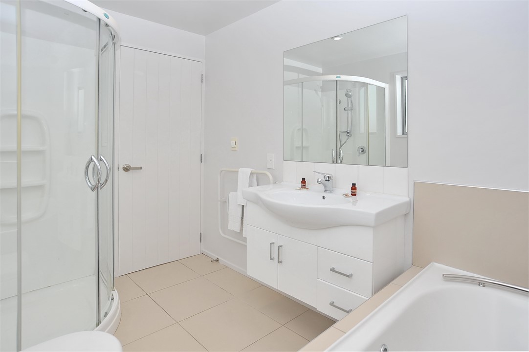 Bathroom 1 has a shower, bathtub and a toilet