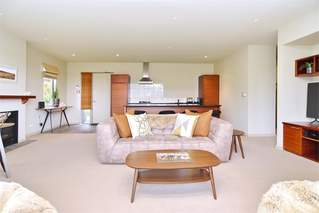 Living area with a TV and the kitchen in the backg