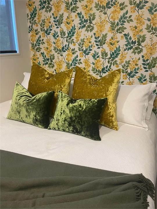 Queen bed with walk in wardrobe and TV.