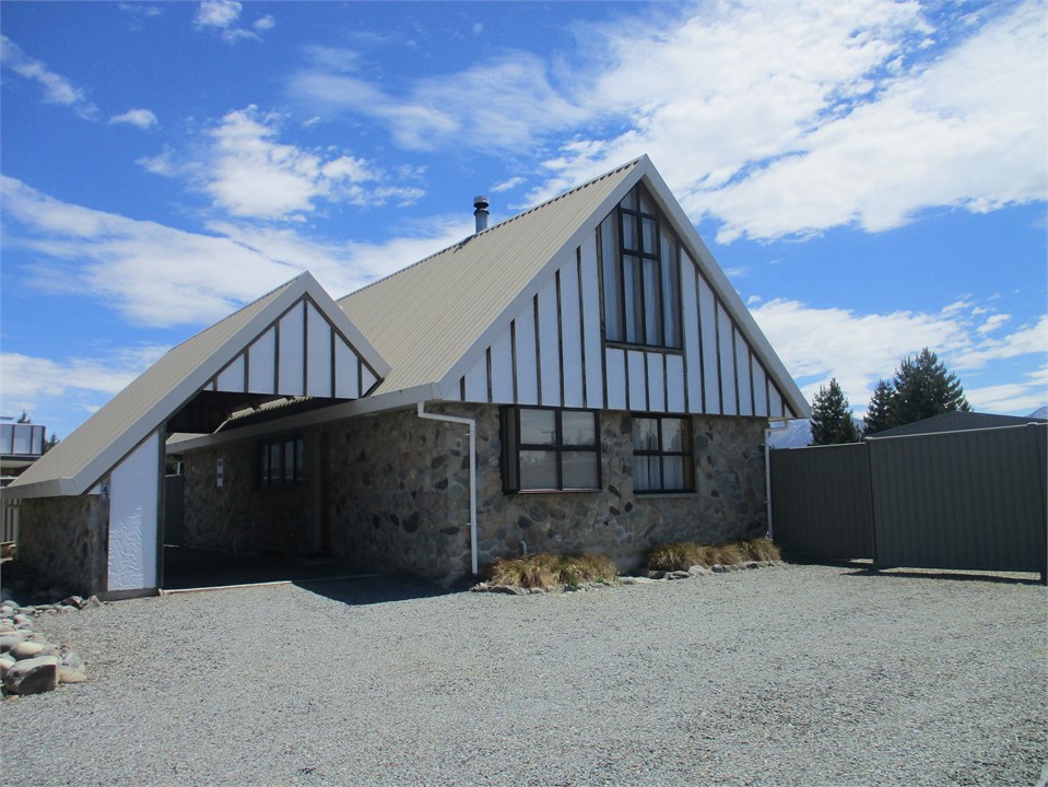 Front of house with a carport and parking area