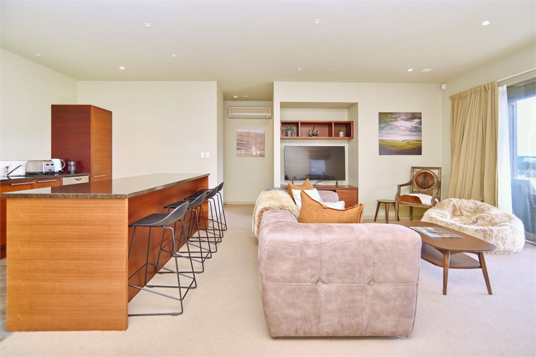 Living area with a TV and the Kitchen to the left