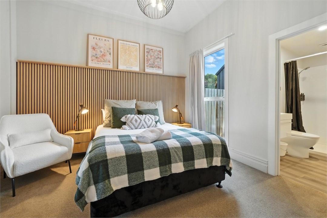 Bedroom 1 with a Queen bed, ensuite and seating ar