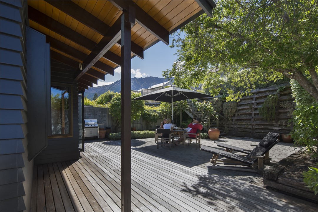 Sunny backyard with BBQ, sun loungers & furniture