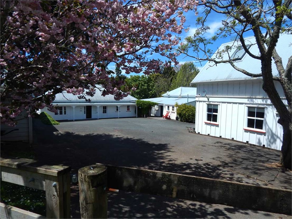 View across the carpark to the house, barn and din