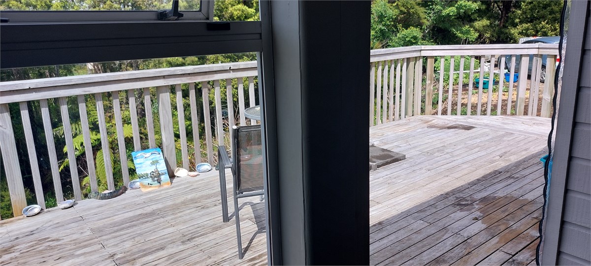 View out from cafe area, towards deck and bush, th