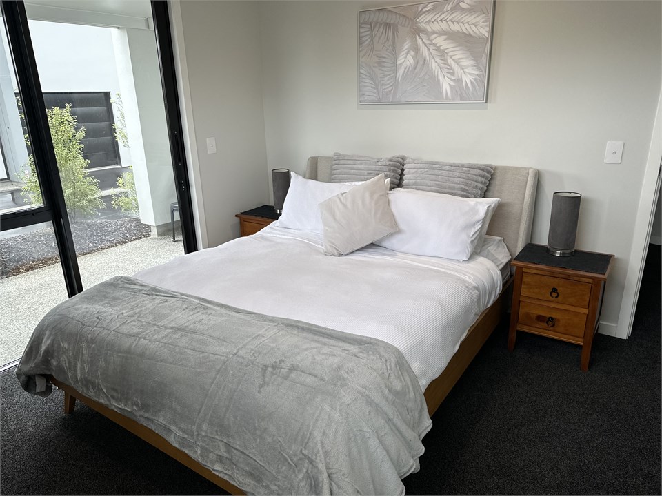 Queen bedroom looking out onto ground floor patio