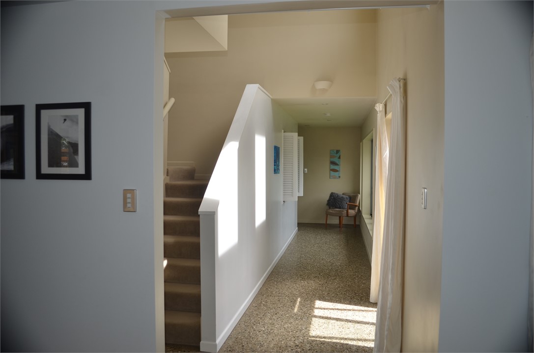Stairs to master bedroom and sunny hall to downsta