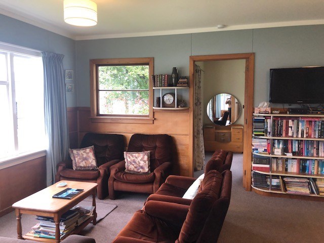 Lounge with well stocked bookcase and TV