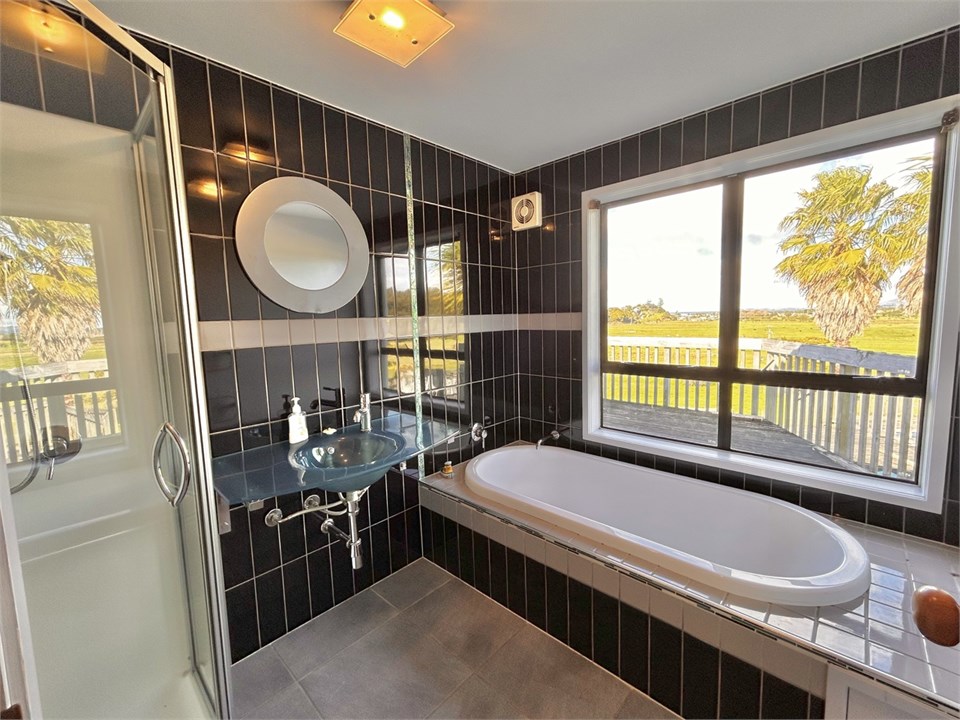 Bathroom 1 with shower, bath, basin and ocean view