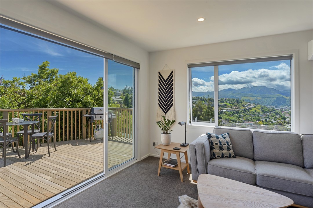 Living area opening on sunny deck with sea views