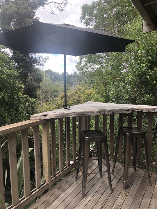 Bar leaner at end of deck with view to bush and su