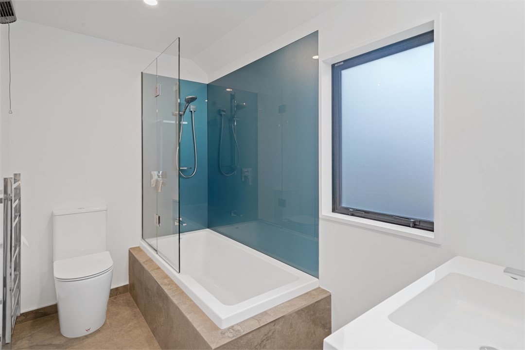 Bathroom 1 has a shower, bathtub and a toilet