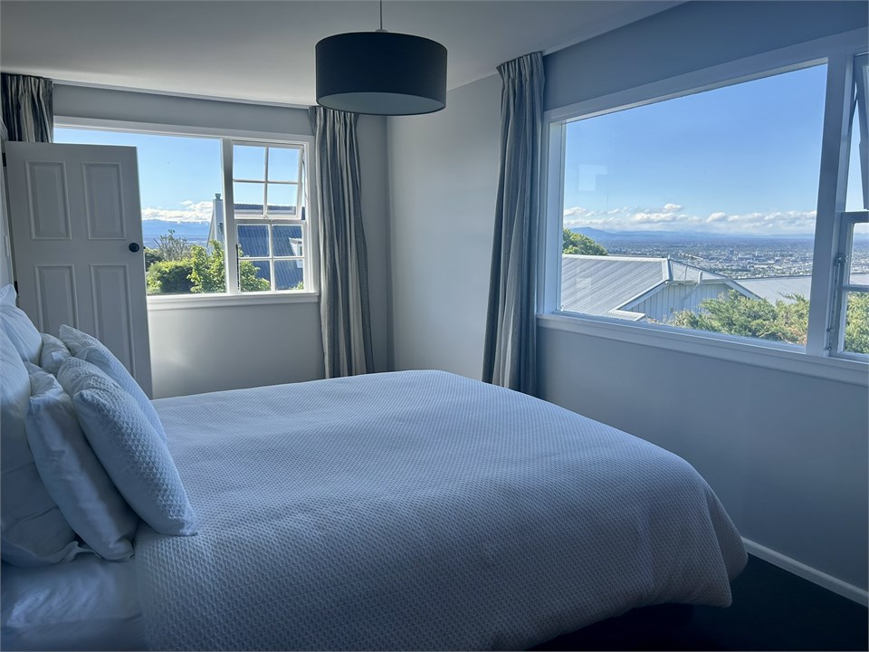 Bedroom with king size bed, city and coast views