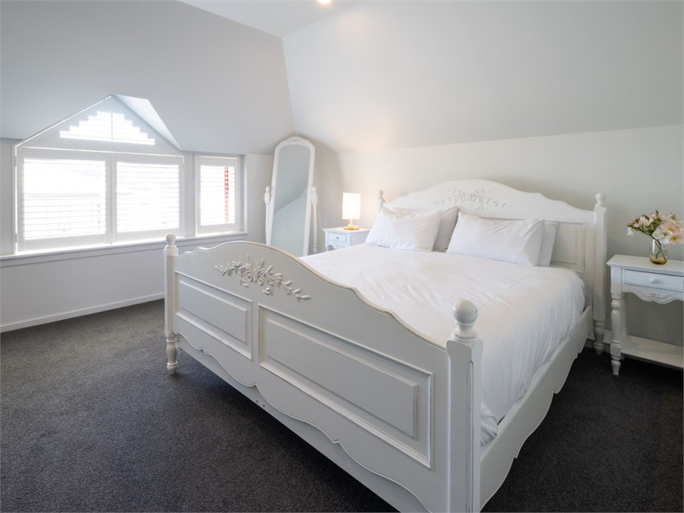 A crisp white master bedroom with painted white fu
