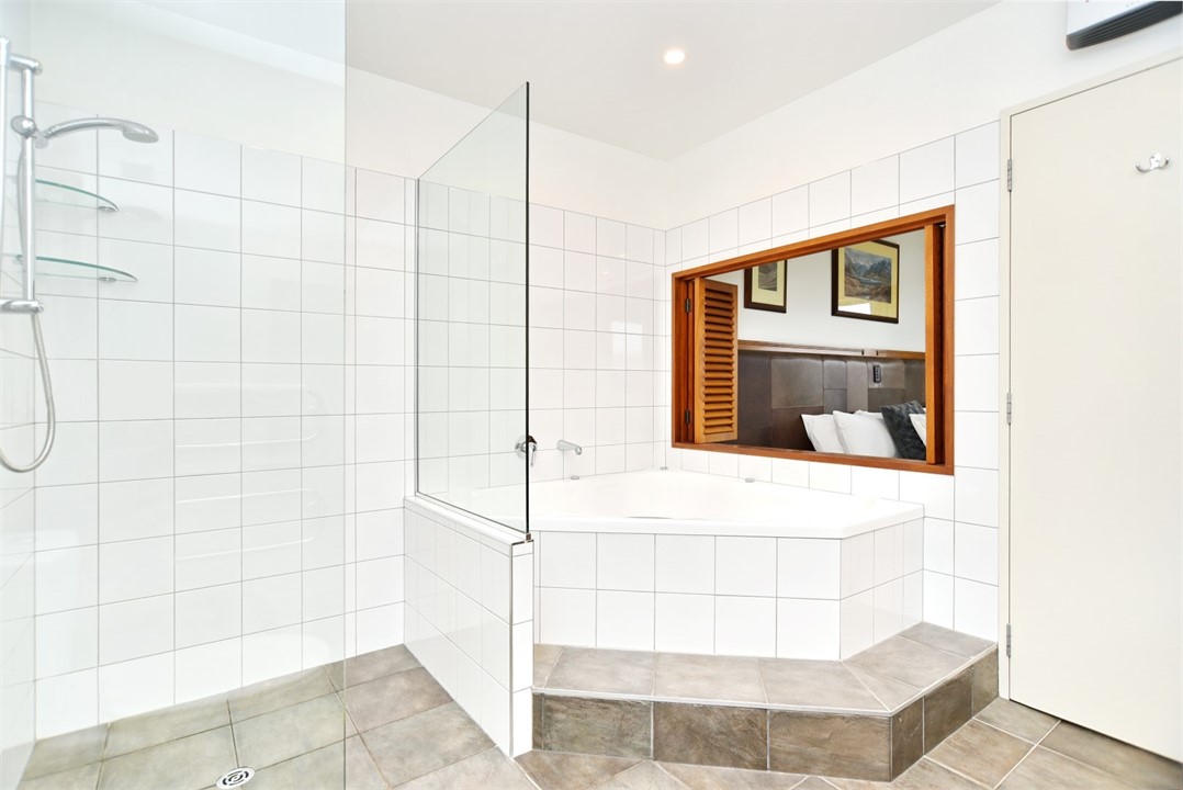 En suite to Bedroom 1 with a spa bath, shower and 