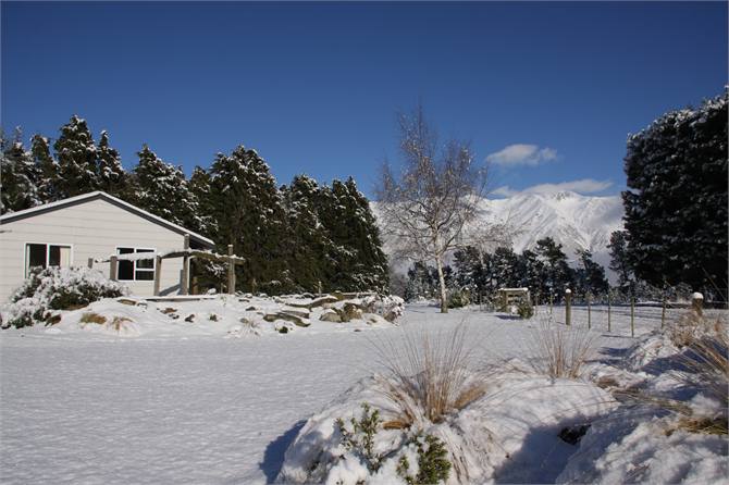Snow blankets the lawn and garden.
