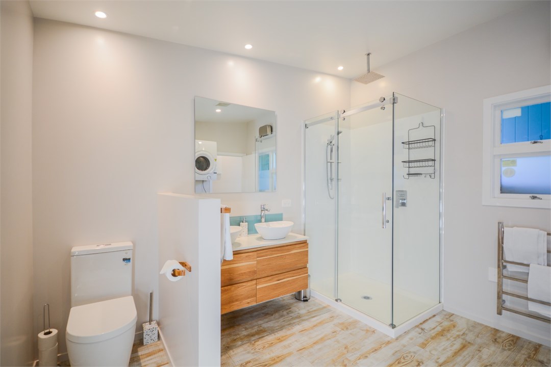 Bathroom has a shower, toilet and laundry area