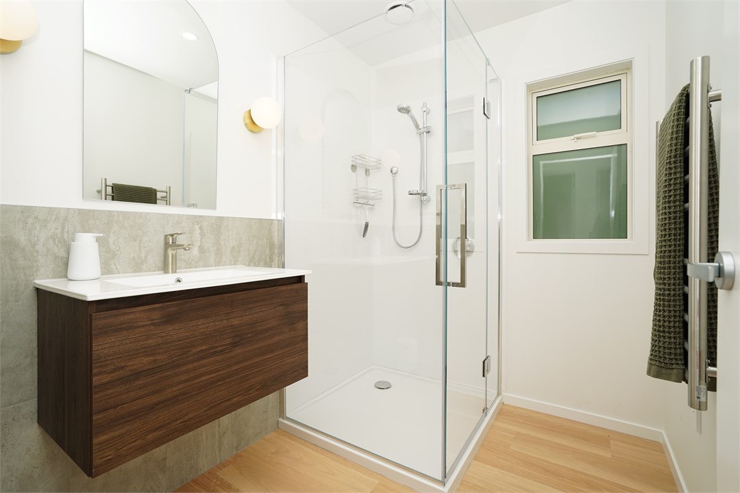 Bathroom has a shower with a separate toilet area